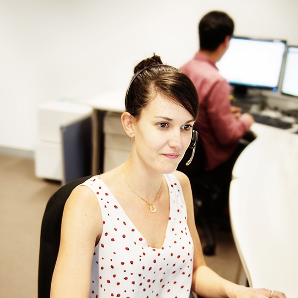 Staff member wearing headset working at desk